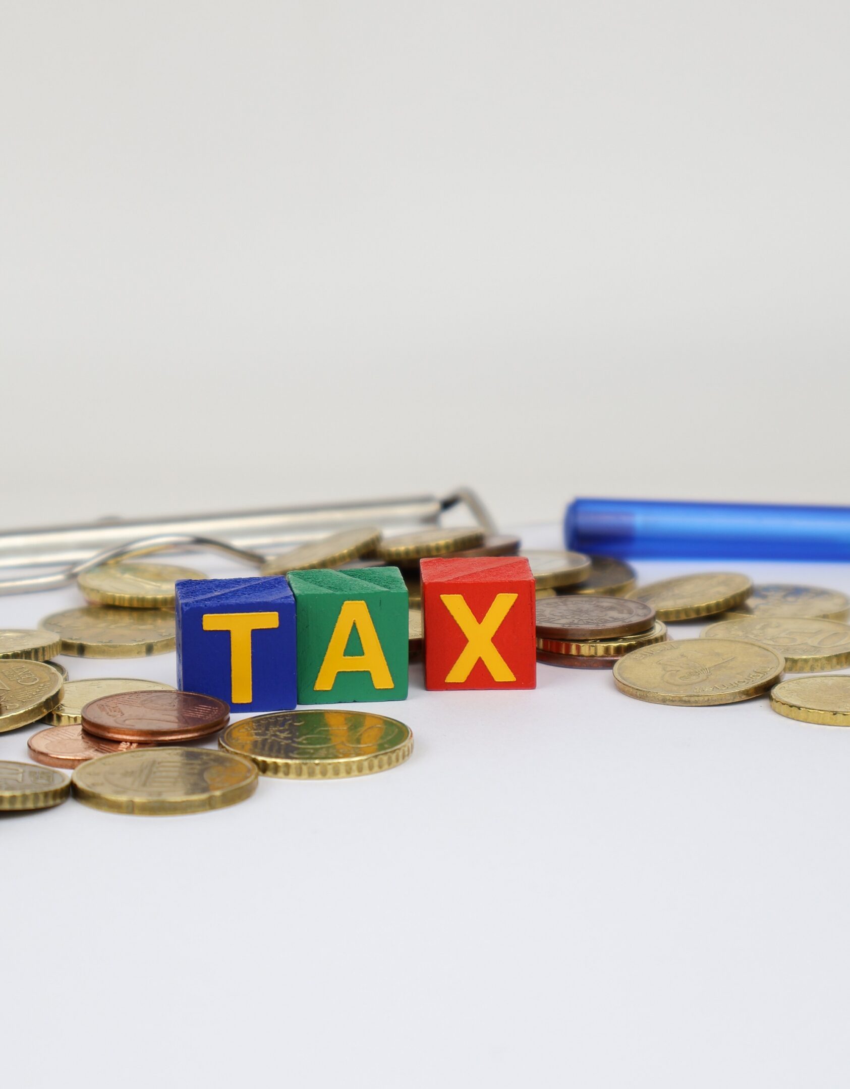 Colorful blocks spelling "tax" with coins.