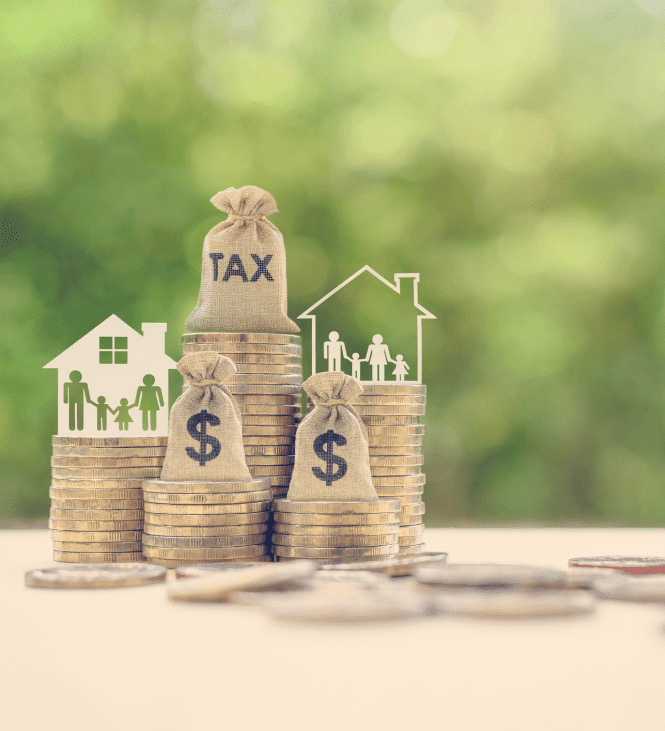 Stacks of coins with tax and dollar bags.