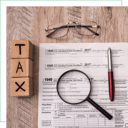 Tax forms with magnifying glass and pen.
